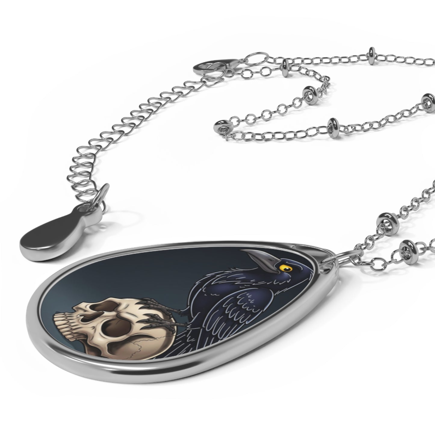 Teardrop-shaped pendant with skull design on a white background